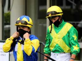 Masked jockeys following the return of racing.
